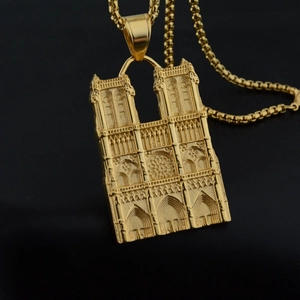 Detailed close-up of golden Notre-Dame cathedral pendant with gothic architectural relief
