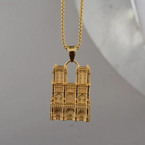 Close-up of golden Notre Dame pendant with fine embossed details and durable box chain