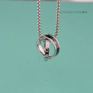 Macro shot of interlocking silver rings engraved with Love and Forever on a blue background