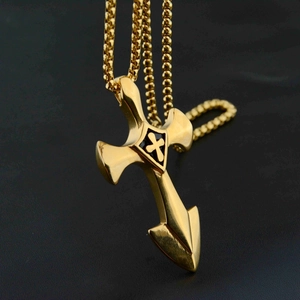 Makro-Nahaufnahme von goldenem Schwertkreuz-Anhänger mit schwarzem Schild und Kugelkette