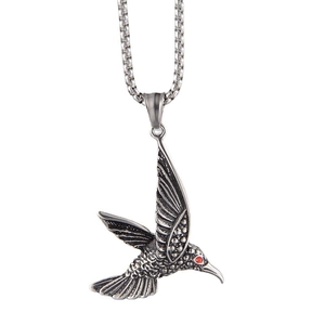 Détail macro du pendentif colibri avec texture de plumes et incrustation de gemme rouge