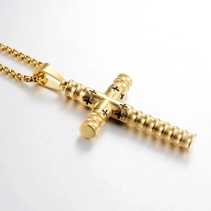 Nahaufnahme des goldenen Zylinder-Kreuzanhängers mit schwarzen Gravuren und Kette