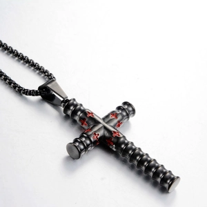 Nahaufnahme von schwarzem Kreuzanhänger mit rotem Stern und Metall-Perlenkette