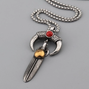 Detailed view of vintage Indian style feather pendant with crescent horn and red bead inlay