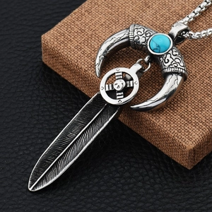Vintage antique silver horn and feather necklace featuring a turquoise gemstone pendant
