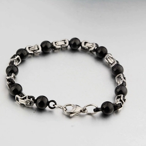 Dettaglio del bracciale in acciaio al titanio con perline di onice nera e catena bizantina