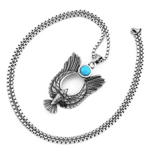 Détail du pendentif aigle argenté vintage avec pierre bleue sur une chaîne robuste