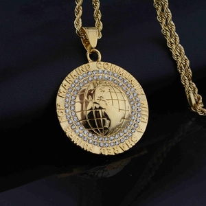 Macro shot of gold world map pendant with zircon inlay and shared future engraving