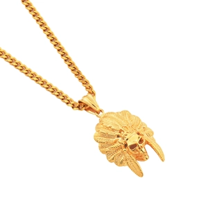Macro detail of golden Indian skull pendant with feathered headdress on a curb chain