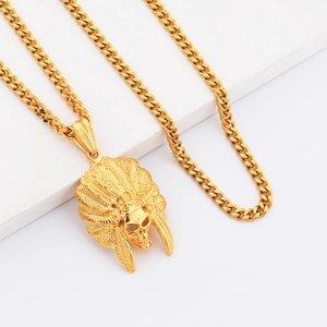 Close-up of golden Indian feather skull pendant with detailed Cuban chain necklace