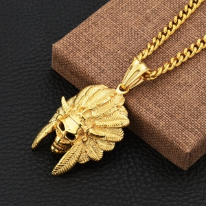 Close-up of golden Indian skull pendant with feather headdress on a thick cuban chain link