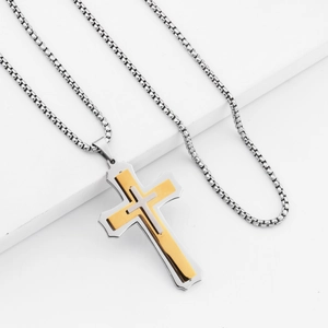 Close-up of triple-layered cross pendant with gold and silver finishes on box chain