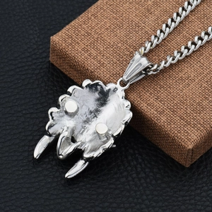 Macro view of a silver beast claw pendant with detailed casting on a Curb chain necklace