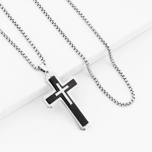 Macro detail of triple layered cross pendant on box chain with black enamel inlay finish