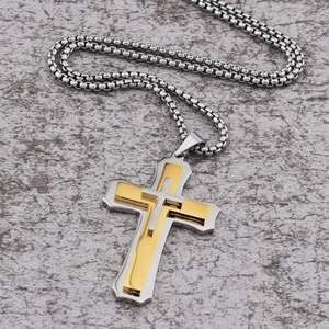 Macro detail of triple-layer cross pendant in gold and silver finish with box chain