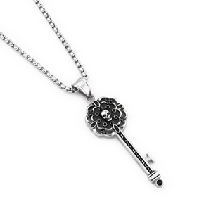 Gothic skull key pendant necklace with black gemstones and box chain on white background
