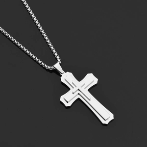 Detail of silver triple-layered cross pendant with sleek box chain on black surface