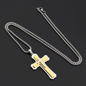 Close-up of triple-layered cross pendant with gold brushed finish and silver box chain