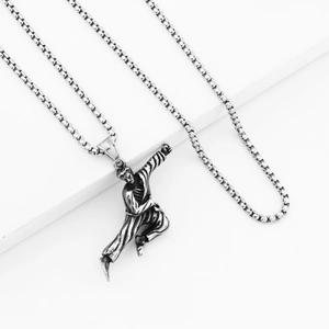 Macro detail of silver martial arts pendant featuring a high-kick kung fu figure