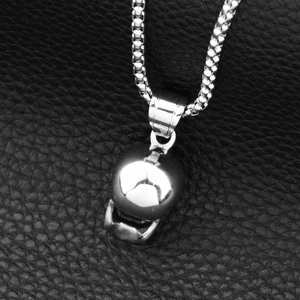 Polished silver skull pendant hip hop necklace with box chain on black leather background