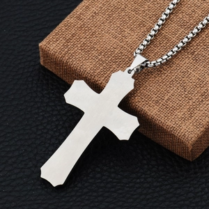Macro detail of silver triple cross pendant with brushed steel finish on box chain