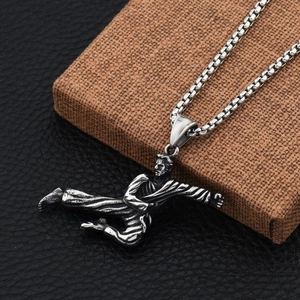 Detail shot of vintage silver martial arts pendant featuring a dynamic side kick pose