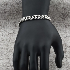 Detailansicht eines polierten Edelstahl-Panzerarmbands an einem Handdisplay