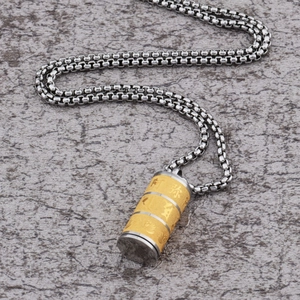 Dettaglio del ciondolo a cilindro rotante con mantra oro e argento su catena