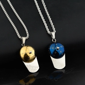 Close-up of gold and blue baseball cap pendants with Keep Me Warm engraving detail