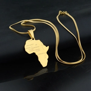 Macro detail of gold Africa map pendant with engraved regions on a sleek snake chain