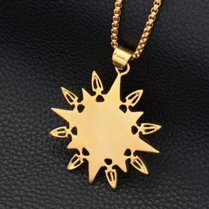 Gold sun compass pendant necklace with box chain on black leather background