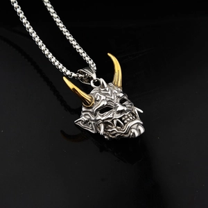 Vue détaillée du pendentif masque Prajna bicolore argent et or avec sa chaîne fine