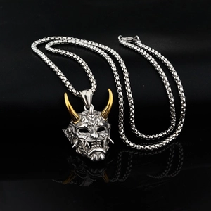 Détail du pendentif masque Prajna argenté avec cornes dorées sur fond miroir