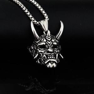 Gros plan du pendentif masque Hannya en argent avec une chaîne maille vénitienne