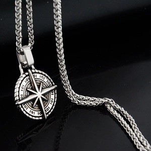 Silver stainless steel compass star pendant necklace with wheat chain on black background