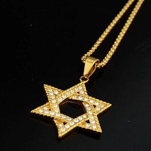 Gros plan détaillé d'un collier pendentif hexagramme doré serti de cristaux brillants