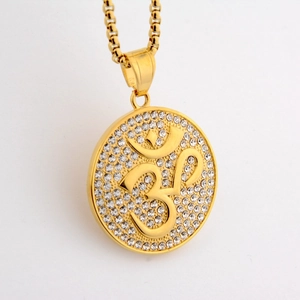 Detailed close-up of golden Om pendant with sparkling crystal inlay on a gold chain