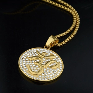 Macro shot of gold Om pendant necklace with sparkling rhinestones and box chain detail