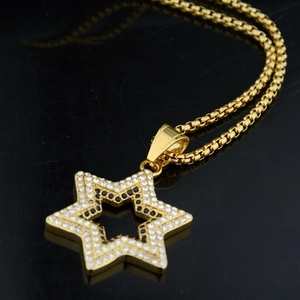 Hip hop gold hexagram pendant necklace with sparkling stones on black surface