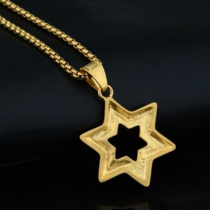 Close-up of gold hexagonal star pendant with matte finish and box chain on black leather