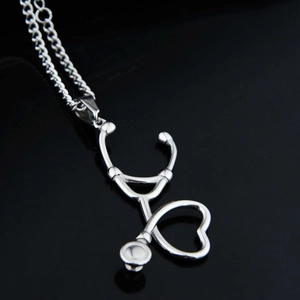 Détail macro du collier pendentif stéthoscope en argent avec forme de cœur sur fond noir