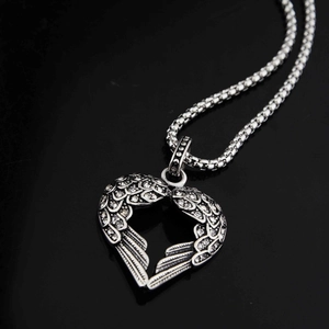 Vue détaillée du pendentif cœur avec ailes argenté orné de pierres de zircone cubique