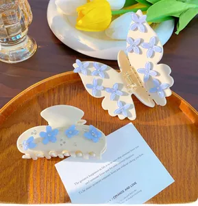 Dettaglio dei fermagli per capelli a farfalla color crema con fiori fatti a mano e strass