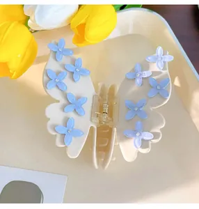 Dettaglio della grande pinza per capelli a farfalla con piccoli fiori e strass
