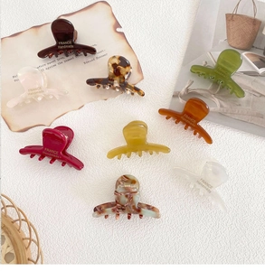Detailed macro view of nine colorful handmade acetate hair claws with premium glossy finish