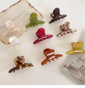 Close-up of colorful acetate hair claws with France Handmade text on beige background