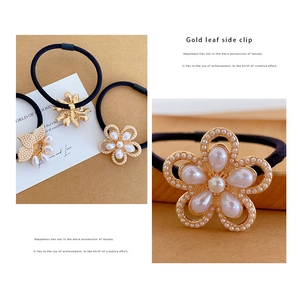 Detailed set of floral hair ties featuring gold leaves and pearls on black elastic bands