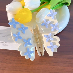 Elegante molletta per capelli a farfalla con fiori blu e strass su bianco crema