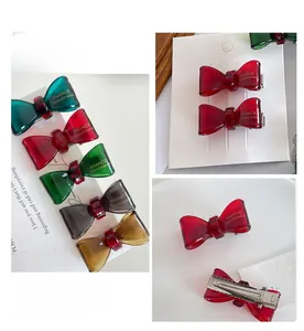 Detail of vintage resin bow hair clips in multiple colors with metal duckbill clips