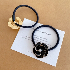 Eleganti elastici per capelli con fiori di camelia neri e accenti dorati da donna